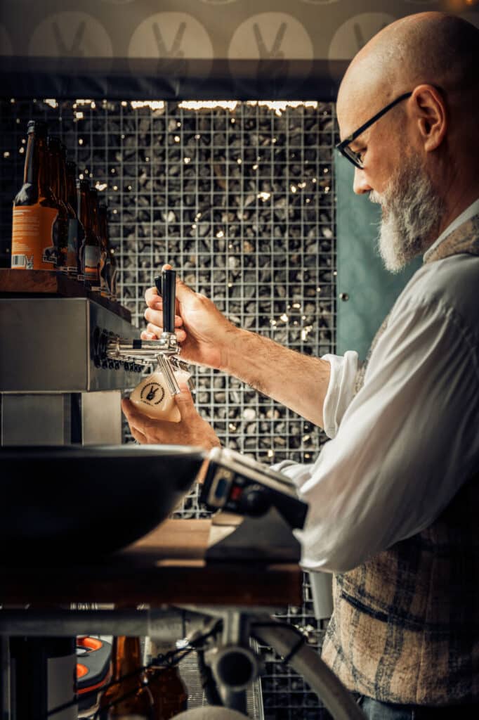 Man tapt een glas bier in café