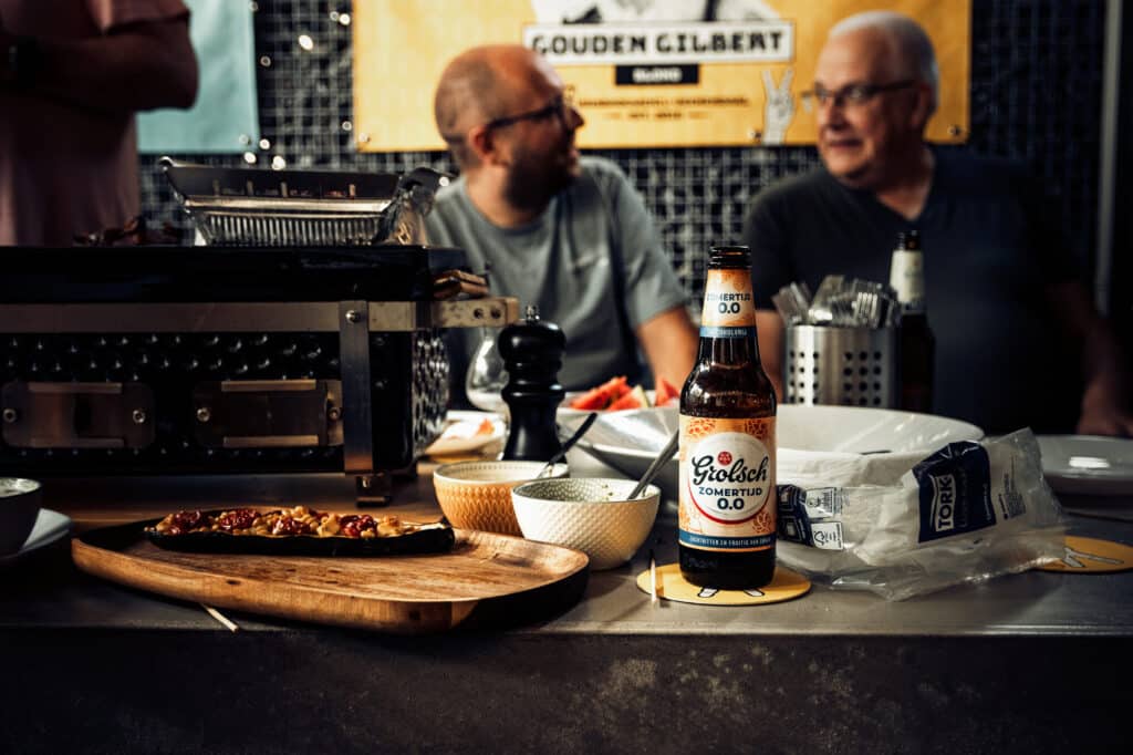 Twee mannen bij barbecue met Grolsch bier.