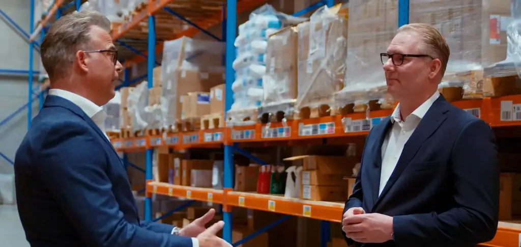 Twee mannen in een magazijn converseren